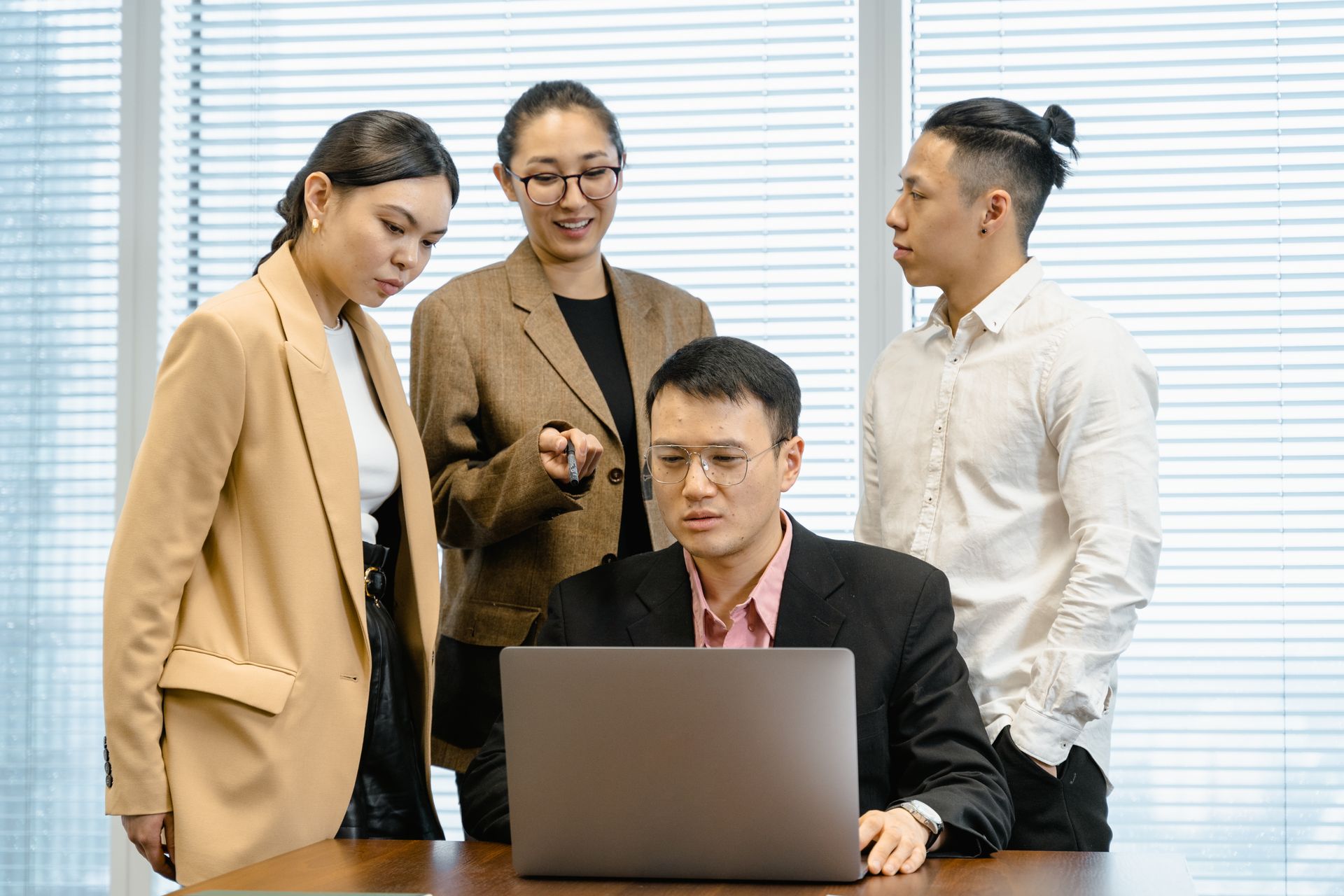 Colleghi che discutono di un lavoro attorno a un laptop in ufficio